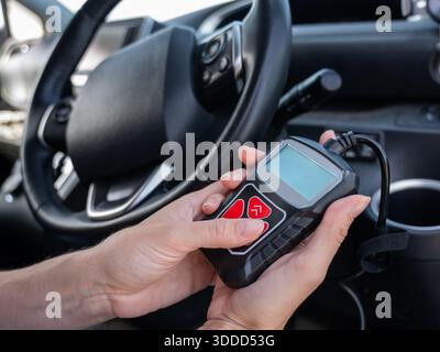 Woman using OBD2 diagnostic scanner.  Stock Photo