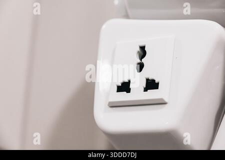 White universal power outlet socket on a wall providing electrical power for charging devices and electronic equipment Stock Photo