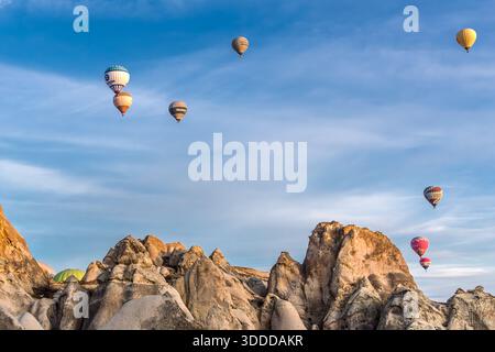 Hot air balloons rise above the rock formations of Göreme, Central Anatolia Region, Turkey. Tuff stone landscape and fairy chimneys Stock Photo