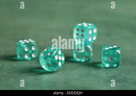 Turquoise game dices on green background Stock Photo