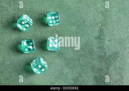 Turquoise game dices on green background Stock Photo