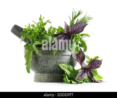 Mortar with fresh herbs and pestle isolated on white background Stock Photo