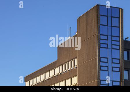 Borken, NRW, Germany, Modern brutalist building facade featuring concrete texture and reflective blue windows Stock Photo