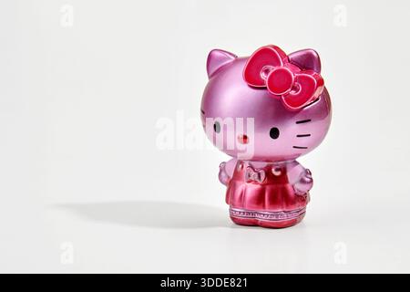 Figurine of pink Hello Kitty with red bow and dress on white background Stock Photo