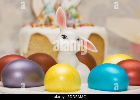 Traditional Easter dinner or brunch with ham, colored eggs, hot cross buns, cake and vegetables. Easter meal dishes with holday decorations. Stock Photo