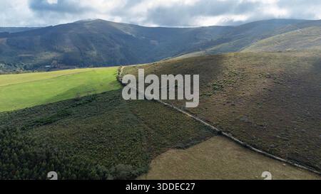 Drone view of a mountain landscape with a mountainside along which a path runs, disappearing into the distance,  Taramundi, Asturias, Spain Stock Photo
