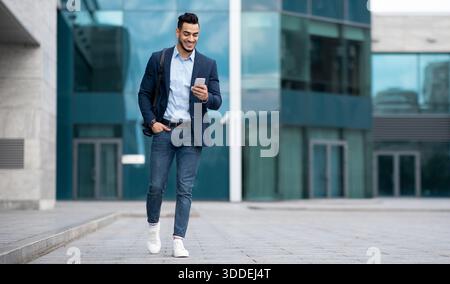 Confident arabic guy programmer with backpack walking by street Stock Photo