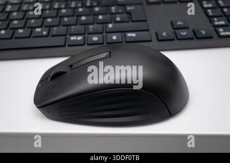 A modern black computer mouse rests on a white background Stock Photo ...