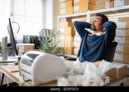Label printer malfunction on work desk while stressed warehouse owner faces business problems and operational failure in storage office || Model released Stock Photo