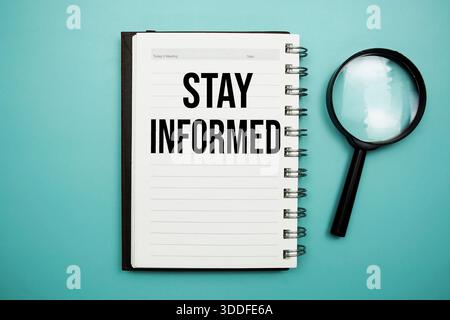 Stay Infomed text written on notepad with alarm clock Stock Photo