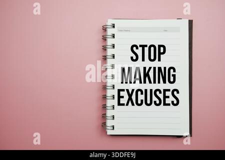 Stop Making Excuses text written on notepad with alarm clock Stock Photo