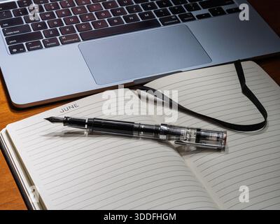 A creative June journaling session featuring analog writing tools alongside a digital workspace setup. Stock Photo