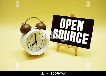 Open Source text message and alarm clock on yellow background Stock Photo