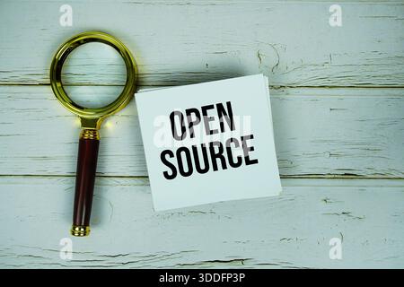 Open Source text with magnifying glass on wooden background Stock Photo