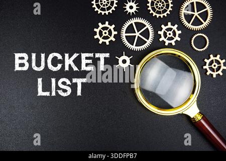 Bucket List text message with magnifying glass on black background Stock Photo