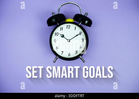 Set Smart Goals text and alarm clock on purple background Stock Photo