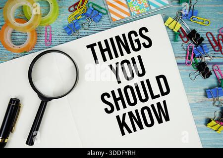 Things You Should Know text written on notepad with magnifying glass flat lay on wooden background Stock Photo