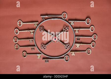 Sixteen vintage,antique keys in a circle with a marble in the in the center. On a leather background. Stock Photo