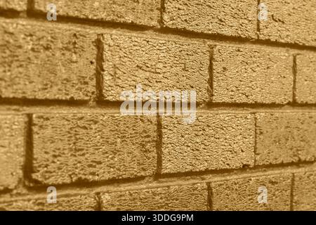 Brick wall background backdrop painted with metallic gold coloured paint. Interior design concept. Stock Photo