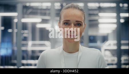 Close up of Confident Woman Working in Clean, Structured Environment of Secure Data Facility. Female Expression Friendly Yet Professional. Technical Competency and Reliable Infrastructure. Portrait. Stock Photo