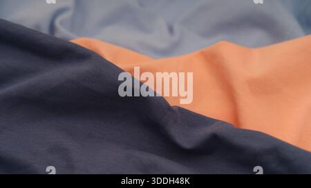 Soft cotton fabric textures in peach, light blue, and navy blue colours. Stock Photo
