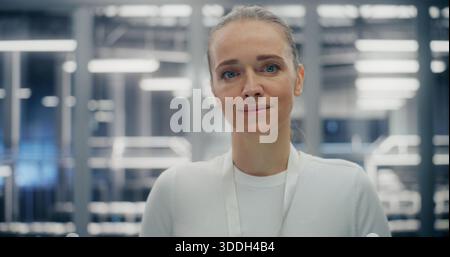 Close up of Confident Woman Working in Clean, Structured Environment of Secure Data Facility. Female Expression Friendly Yet Professional. Technical Competency and Reliable Infrastructure. Portrait. Stock Photo