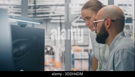 Specialists Discussing Manufacturing Specifications. Two Technical Specialists Deeply Engaged in Design Review, Examining Complex Technical Models on Computer Screen. Critical Problem Solving. Stock Photo