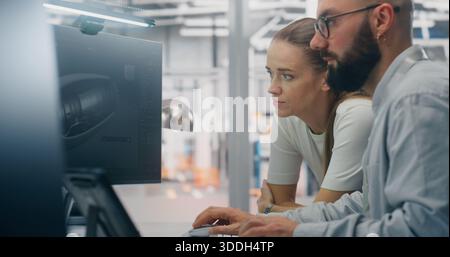 Specialists Discussing Manufacturing Specifications. Two Technical Specialists Deeply Engaged in Design Review, Examining Complex Technical Models on Computer Screen. Critical Problem Solving. Stock Photo