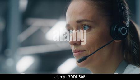 Close Up of Dedicated Female Technician Responding to Real Time System Alerts, Communicating Via Headset at Console in Data Center. Concept of Critical Incident Management and Rapid Response. Stock Photo