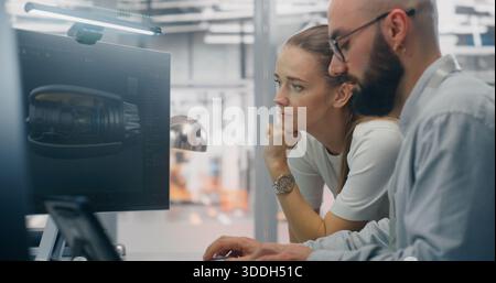 Specialists Discussing Manufacturing Specifications. Two Technical Specialists Deeply Engaged in Design Review, Examining Complex Technical Models on Computer Screen. Critical Problem Solving. Stock Photo
