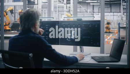 Experienced Manager Performs Remote Maintenance and Diagnosis of Industrial Equipment Using Dual Screen Workstation in Modern Data Center. Concept of Predictive Maintenance and Expert Control. Stock Photo