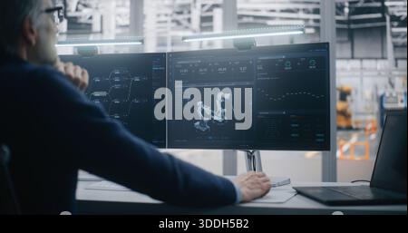 Expert IT Integration, High Skilled Professional With Grey Hair Manages Complex Factory Automation Systems, Using Two Monitors and Laptop. Concept of IT Integration and Expert System Management. Stock Photo
