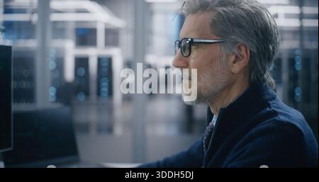 Close Up Experienced IT Professional Performing Network Diagnostics in Mission Critical Server Room. Professional Diagnosing Network Integrity on Workstation. Cybersecurity and System Integrity. Stock Photo