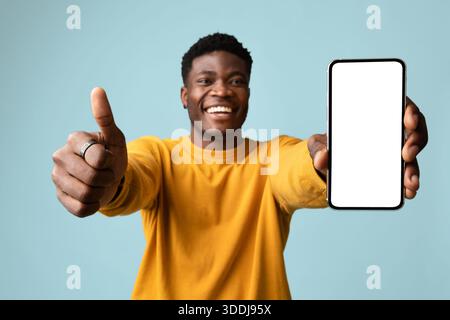 Handsome african american young man showing cellphone, mockup Stock Photo