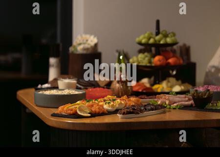 Luxury event buffet. Elegant catering buffet with smoked salmon, cold cuts, devilled eggs, and fresh fruit arranged on a wooden table. Stock Photo