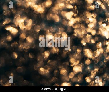 Abstract golden bokeh of out-of-focus ice and frozen droplets, creating a warm shimmering texture. Stock Photo