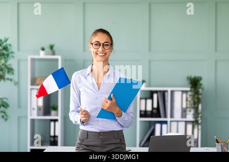 Happy Language Teacher Promotes French in Online Tutoring Session Stock Photo