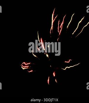 single vivid burst with abstract light trails cutting through black void, energetic red and green streaks twisting outward, minimalist composition evo Stock Photo