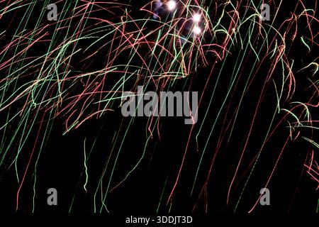 Bright hues dance across dark night sky, Colorful flashes create lively and energetic night sky scene, Dynamic and vivid light fragments scatter acros Stock Photo