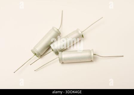 Old capacitors in paper packaging. Aluminum capacitors on a white background. Electronic components. Stock Photo