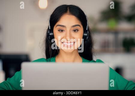 Closeup of beautiful indian woman attending online course, using laptop Stock Photo