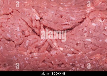 Fresh raw ground beef close up on parchment paper with detailed minced meat texture Stock Photo