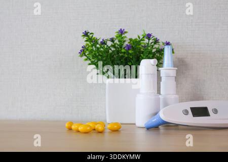 Medical home kit on table: thermometer, nasal spray, pills Stock Photo