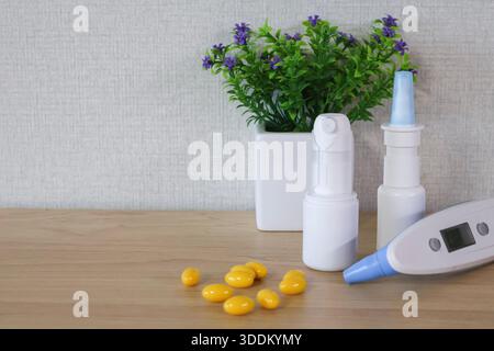 Medical home kit on table: thermometer, nasal spray, pills Stock Photo
