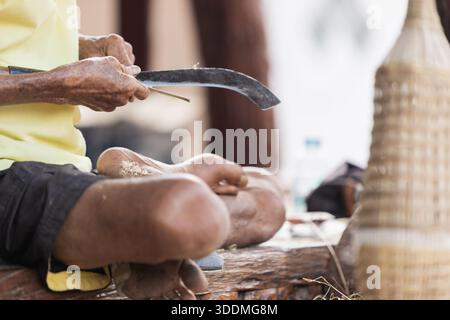 Close up of Thai craftsman using traditional curved knife Stock Photo