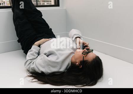 Woman relaxing on floor making a phone call Stock Photo
