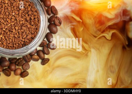 Jar of instant coffee and roasted beans against milk swirls in beverage Stock Photo