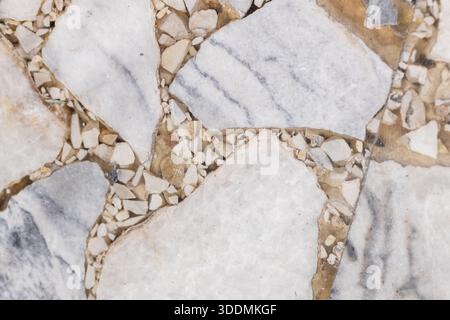 Top view of a flooring built from large flat stones separated by small pebbles and gravel. The textured surface conveys durability, earth tones, and n Stock Photo