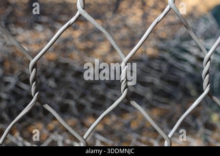 Detailed close up shot of hexagonal metal wire fence with blurred background showcasing rustic pattern and strong mesh structure conveying feelings of Stock Photo