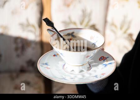 Vintage coffee cup and saucer with half-drunk coffee on sunny terrace, nostalgic morning atmosphere Stock Photo